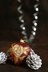 Happy New Year. Mouth blown and hand painted glass heart with pinewood cone in snow. Christmas decor. 