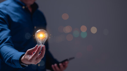 Person holds glowing light bulb, symbolizing creativity and inspiration, while casually engaging...
