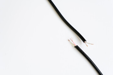 Two ends of a torn cable with a copper core, on a white background. Broken cable requiring repair. Disconnection concept	