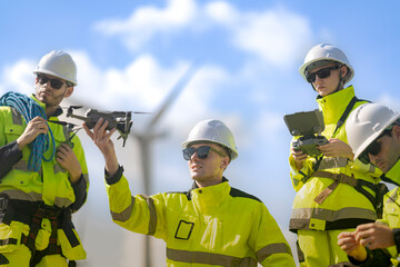 A group of engineers dressed in high-visibility uniforms and helmets conducts an inspection at a...