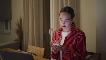 Girl multitasking home office texting smartphone. Remote businesswoman working