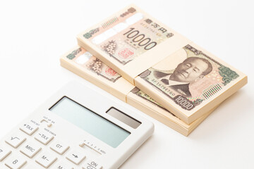 白背景に一万円の札束と電卓