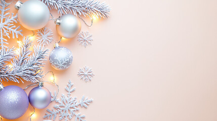 Festive arrangement of Christmas ornaments, decorative snowflakes, and white pine branches on a soft pastel pink background