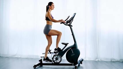 fit woman exercises on an elliptical machine in a modern gym, focusing on cardio and fitness