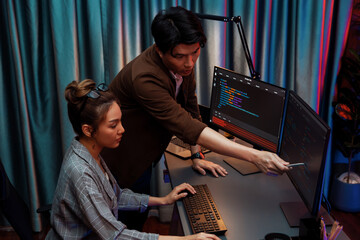 IT developers discussing with point to intelligent website development coder system running data online two screens information technology at neon light room at modern office. Infobahn.