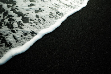 sea foam on black sand