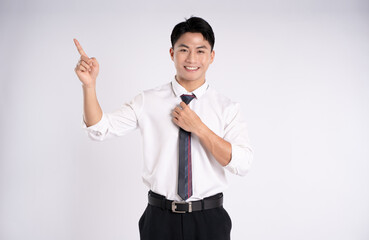 Portrait of young Asian business man posing on white background