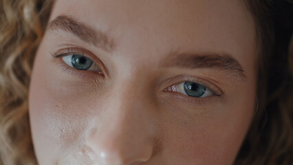 Woman open blue eyes looking camera macro closeup. Serene girl with focused gaze