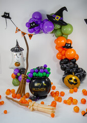 Halloween decorations made of balloons, pumpkin, cauldron and witch's broom