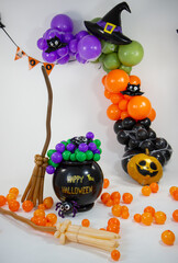 Halloween decorations made of balloons, pumpkin, cauldron and witch's broom