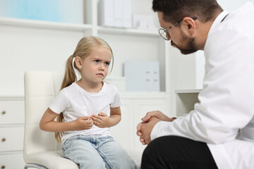 Obraz premium Doctor consulting little girl with stomach pain in hospital