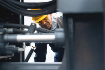 Machinery tractor mechanic checks hydraulic piston hose system equipment on excavator © Parilov