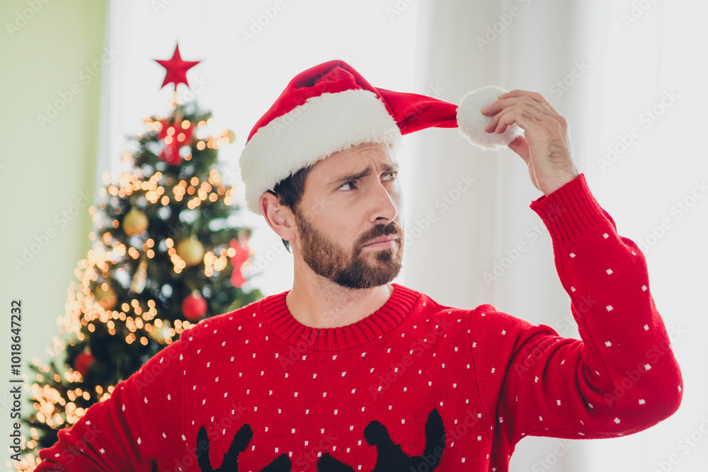 Sticker Photo of nice young man hold look hat pom pom ugly sweater christmas time apartment indoors