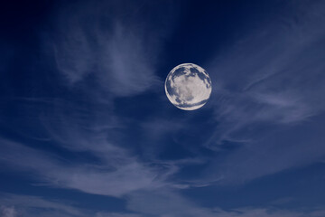 full moon in the night sky among the clouds.