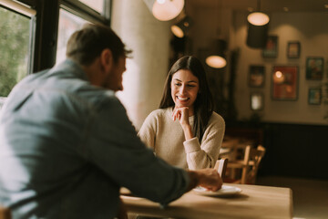 A joyful conversation over coffee and dessert in a cozy café during a sunny afternoon