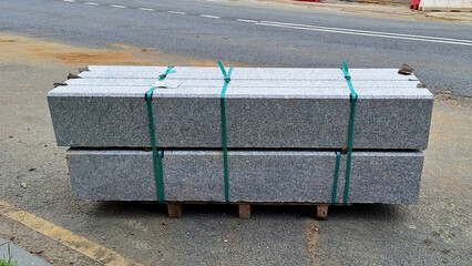 Concrete curbstones stacked on wooden pallet for construction use