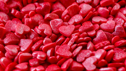 Background of little red and pink hearts.Close-up mini hearts candy.Varied sugar sprinkles, stars, flowers,hearts, dots.Toppings for desserts and ice cream.