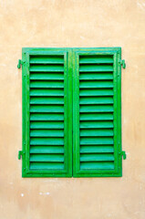 Closed green window on the brown wall. Italy. Florence.