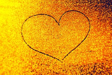 Hand drawn heart on golden sandy background