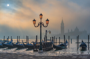 Gondolas in Venice at sunrise in morning fog. Veneto, Italy.. © javarman