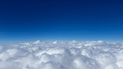 Fototapeta premium Fluffy white clouds float against a vibrant blue sky, illustrating freedom and tranquility, perfect for relaxation and meditation themes