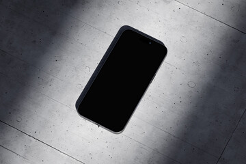Phone with a blank screen on a concrete background