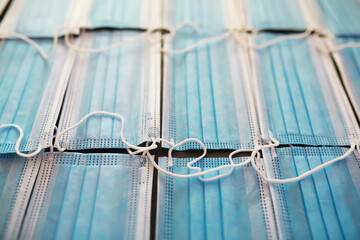Close-up of Blue Surgical Face Masks with White Ear Loops Laid Out Flat