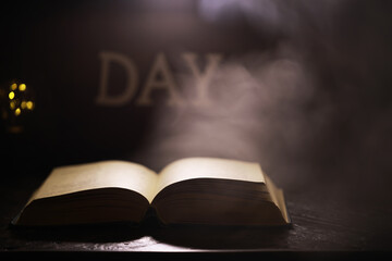 Mystical Open Book with Smoke and Light on Wooden Table in Dark Setting