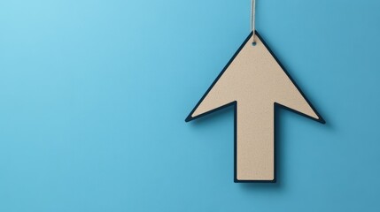 Fototapeta premium Directional arrow sign hanging against a vibrant blue background.