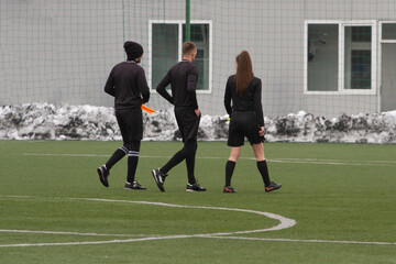 Football referees on an artificial football field