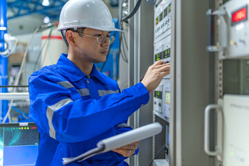 Electrical engineer woman checking voltage at the Power Distribution Cabinet in the control room,preventive maintenance Yearly,Thailand Electrician working at company