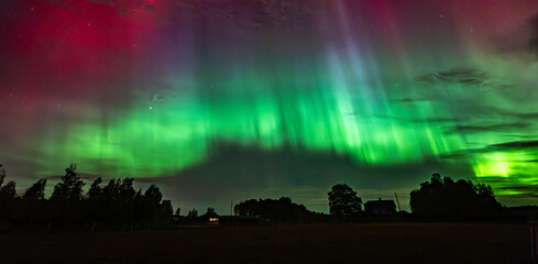 Northern lights dancing over country landscape in noreth of Sweden.