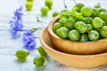 Green Organic Berries Gooseberries.Green gooseberries in a wooden bowl.Gooseberries on the wooden table. Harvest concept. Vegetarian food.