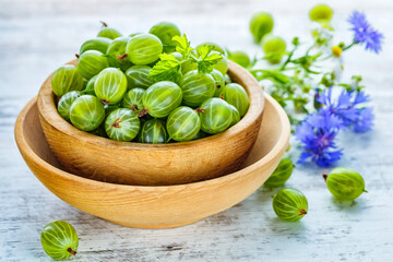 Green Organic Berries Gooseberries.Green gooseberries in a wooden bowl.Gooseberries on the wooden table. Harvest concept. Vegetarian food.