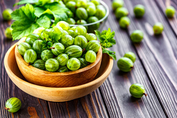 Green Organic Berries Gooseberries.Green gooseberries in a wooden bowl.Gooseberries on the wooden table. Harvest concept. Vegetarian food.