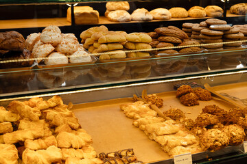 Vibrant bakery display with crispy pastries and colorful cakes behind a shop window, showcasing fresh and delicious treats at a market. Space for text, commercial advertising, banner 