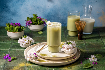 Iced matcha latte drink being prepared with matcha powder and milk