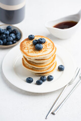 Homemade buttermilk pancakes with blueberries on white plate, closeup view