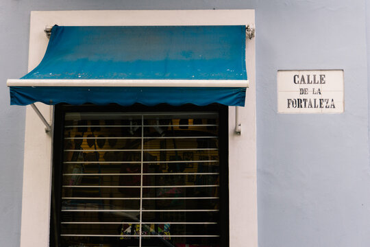 Blue awning over window on purple wall