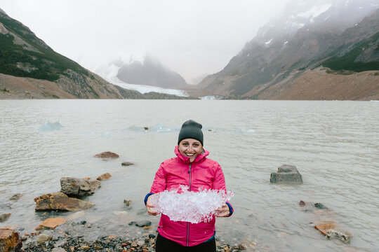 Woman holds piece of glacial ice in hands in patagonia