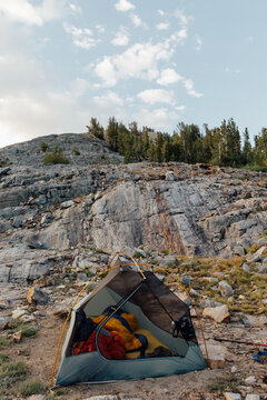 Tent with no fly and sleeping bags against a rocky granite area