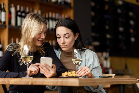 Two friends drink wine in wineshop