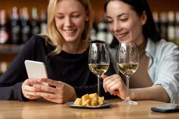 Two glasses with white wine and bowl with cheese