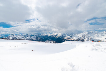 A picturesque view of the rocky white peaks of the mountains of the North Caucasus range from the snow-covered slope of Mount Elbrus. Caucasus