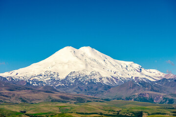 Fototapeta premium Picturesque view of the white peak of Mount Elbrus. View from the Kanjol plateau