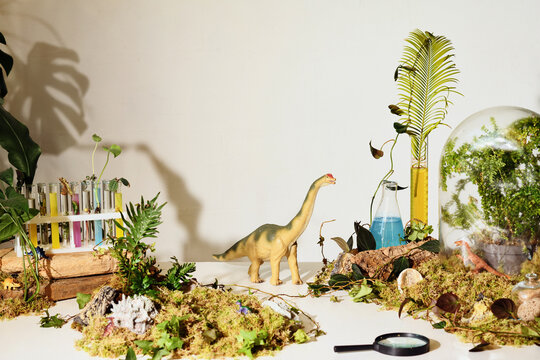 dinosaur explores miniature science environment on table