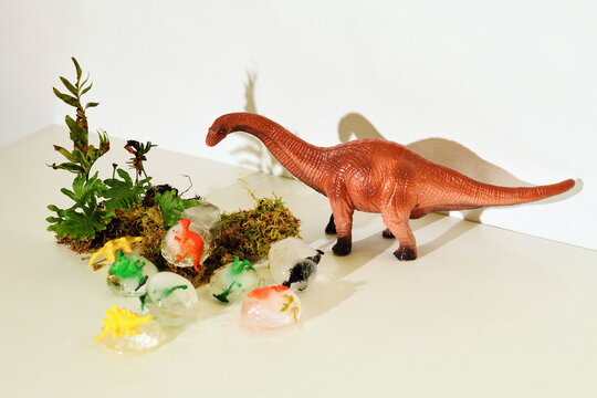 A toy dinosaur explores a miniature landscape with ice creatures