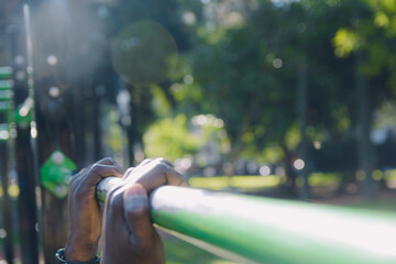 hands hanging from a calisthenics pole