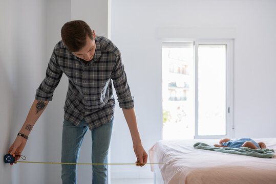 Man making measurements in bedroom