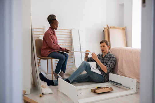 Couple assembling furniture in new apartment